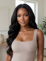 Model wearing the Wig Outlets 13x6 Lace Front Natural Black Body Wave Wig, showcasing the deep, rich natural black color with soft, bouncy body wave curls. The lace front creates a flawless, realistic hairline, while the body wave texture adds volume, movement, and a glamorous, natural look.